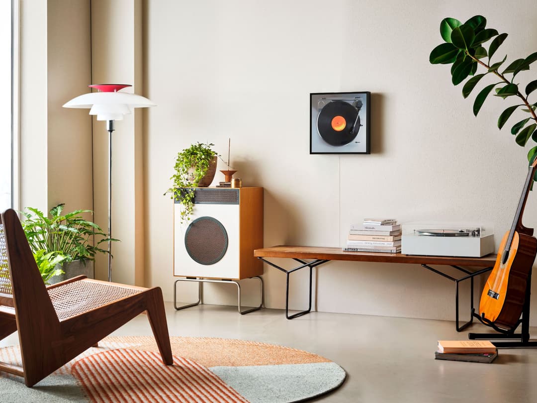 Samsung Music Frame affichant un disque vinyle sur un meuble en bois, dans un intérieur moderne avec plantes et mobilier design