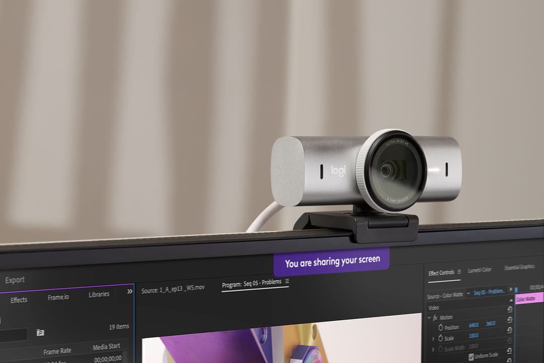 Webcam Logitech gris et blanc montée sur un écran avec logiciel de vidéo en arrière-plan