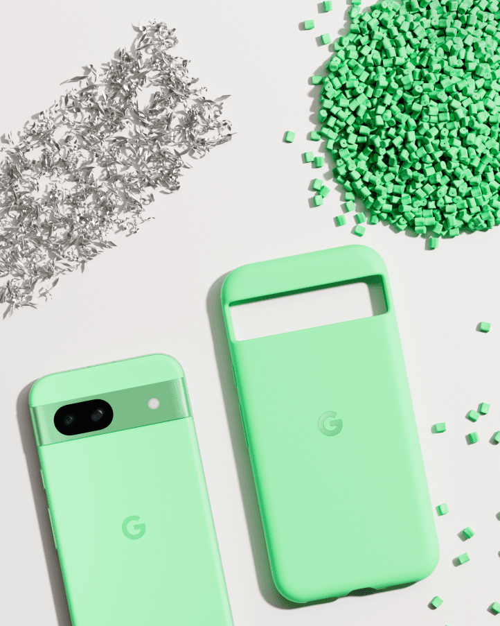Pixel 8a en vert menthe avec son étui assorti, entourés de cubes verts et de matériaux métalliques argentés