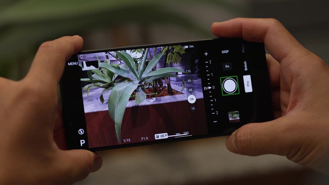 Sony Xperia 1 VI tenant en main, écran affichant une fleur en macrophotographie télézoom avec détails nets et interface de caméra