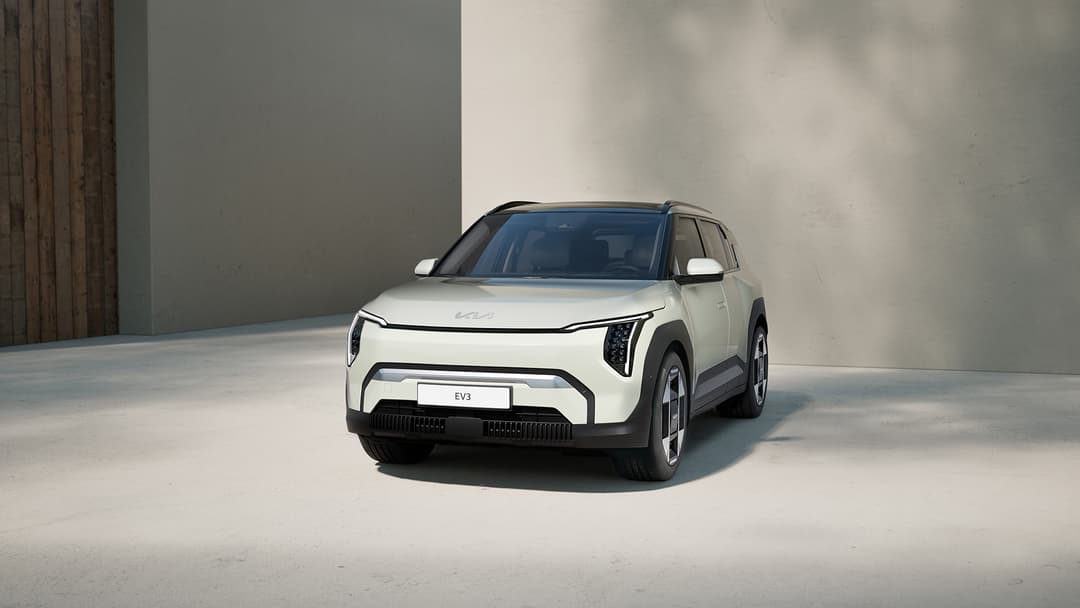 Kia EV3 blanc de trois-quarts avant dans un espace épuré, SUV électrique compact aux formes arrondies