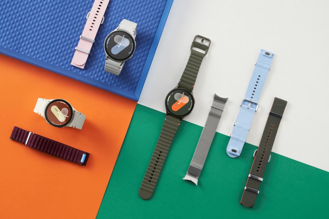 Samsung Galaxy Watch7 avec plusieurs bracelets de couleurs différentes sur fond multicolore bleu, orange et vert