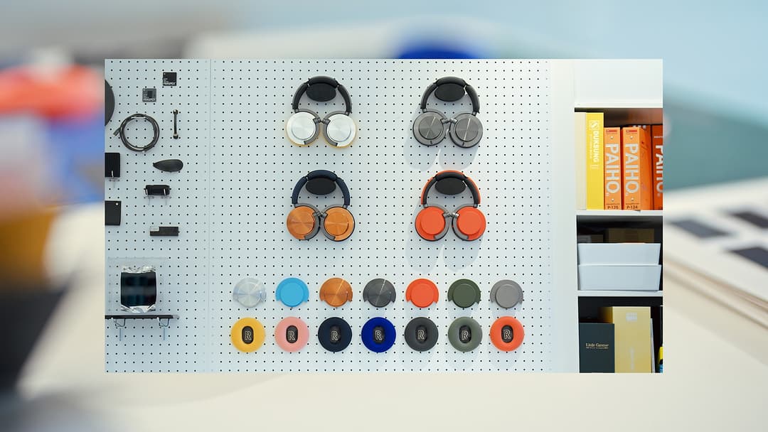 Présentoir mural affichant le casque Dyson OnTrac en cinq variantes de couleurs, avec coques et coussinets interchangeables de diverses teintes