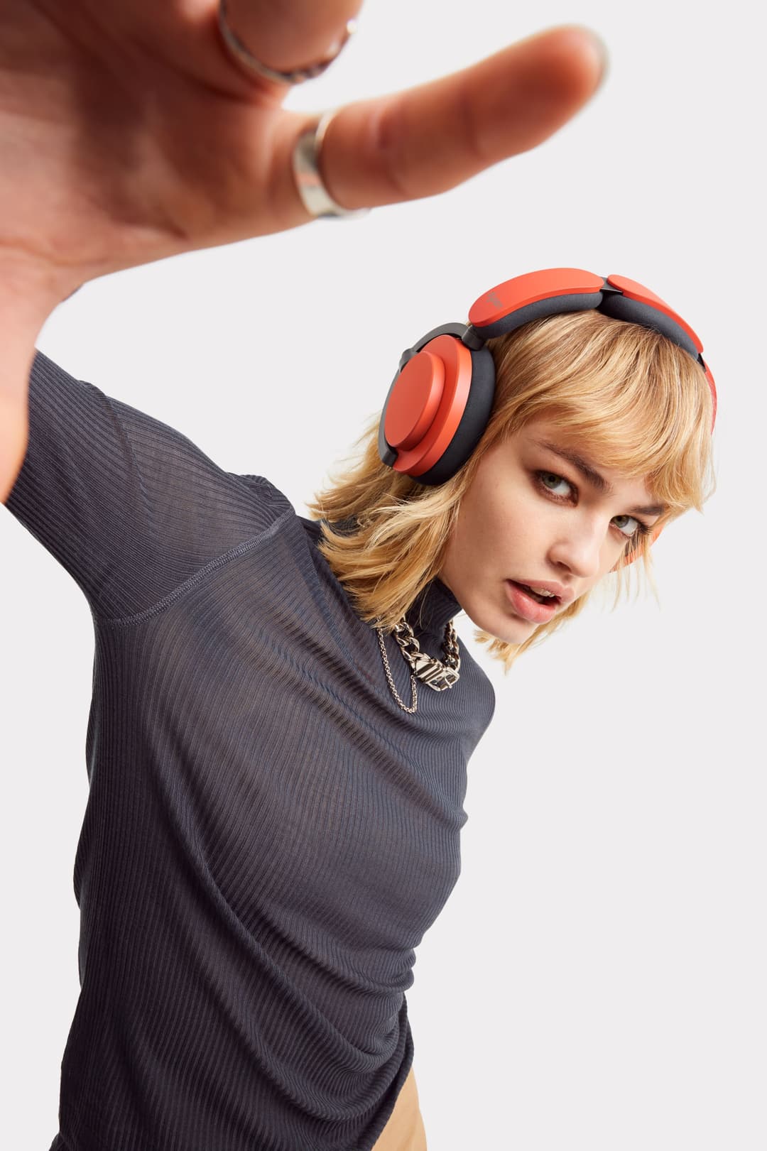 Casque audio Dyson OnTrac rouge et noir porté par une personne, montrant le design des écouteurs et du bandeau
