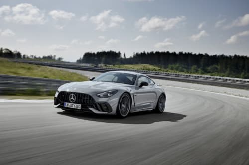 Mercedes-AMG GT 63 PRO 4MATIC+ blanche en virage sur circuit, arbres et ciel nuageux en arrière-plan