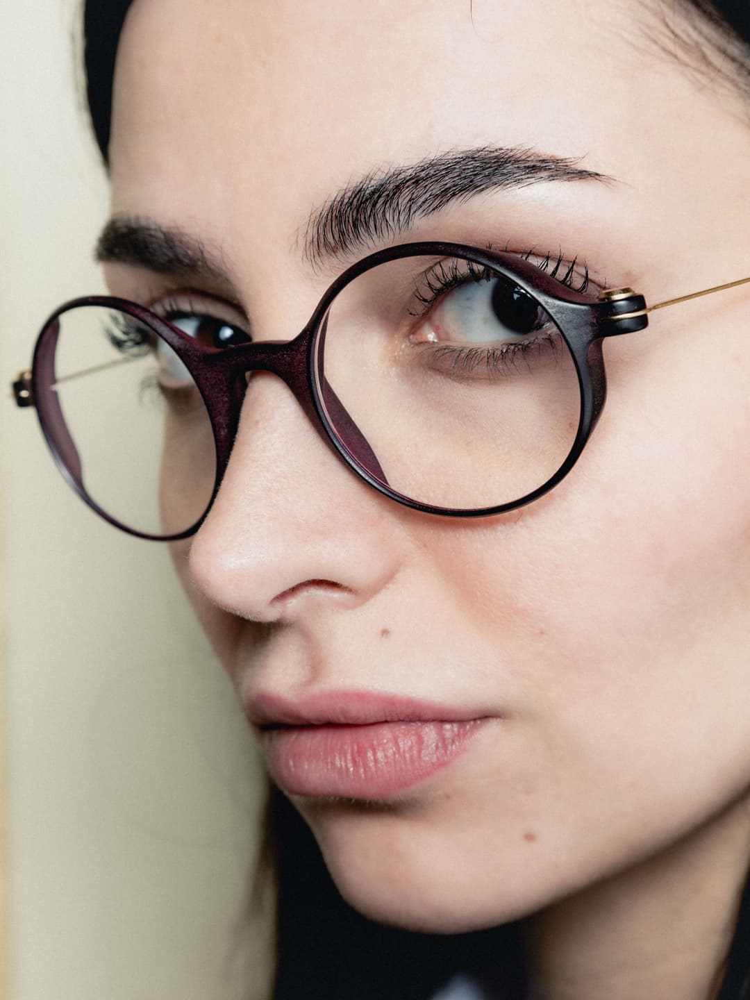 Femme portant des lunettes rondes à monture marron foncé, imprimées en 3D par VISAGES