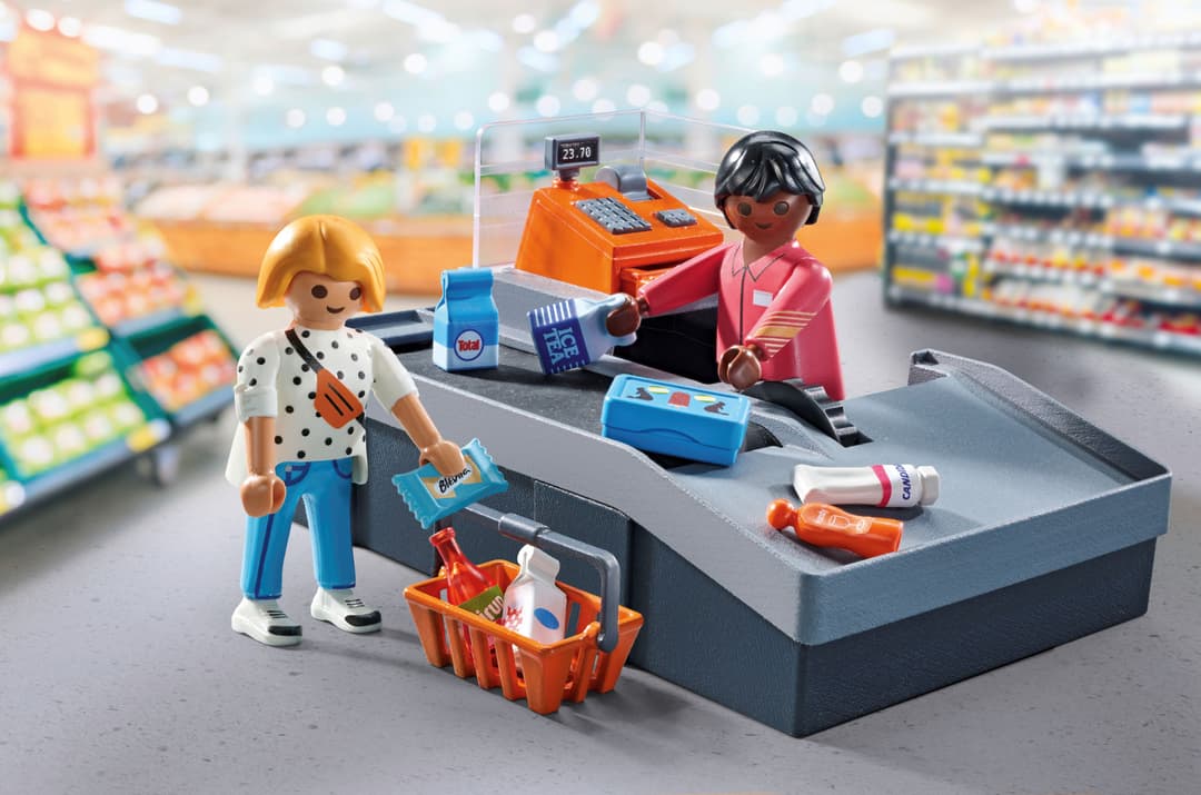 Set PLAYMOBIL représentant une caisse de magasin Migros avec deux figurines, un chariot et des produits miniatures