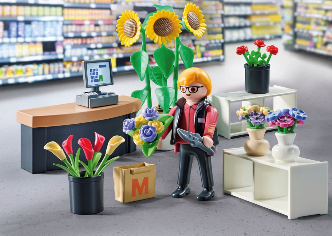 Set PLAYMOBIL exclusif avec figurine de vendeur dans un magasin de fleurs, entourée de pots colorés et de plantes décoratives