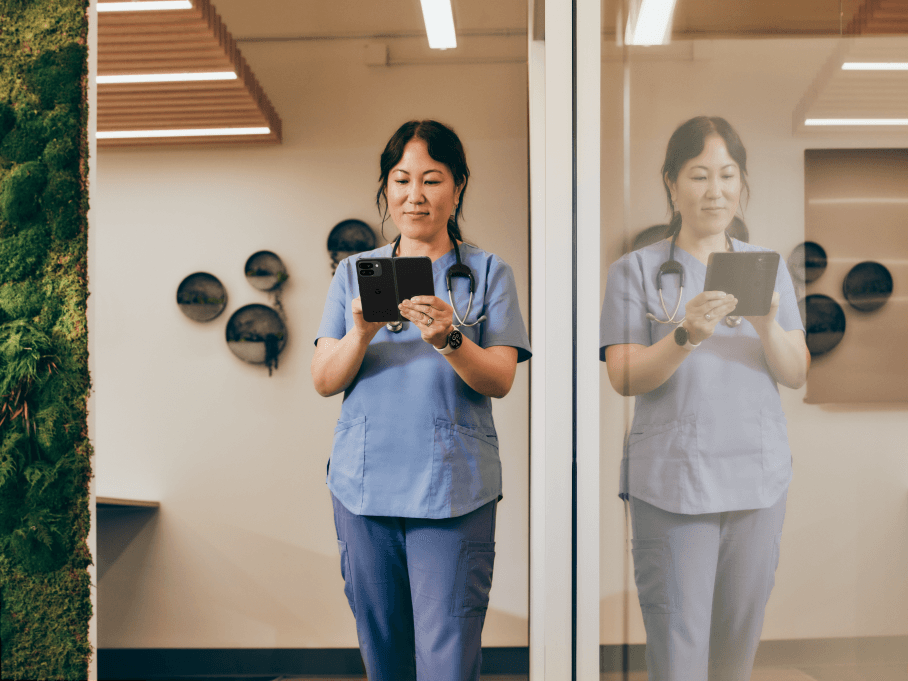Femme médecin en blouse bleue tenant un Pixel 9 Pro Fold ouvert, affichant l'écran extérieur devant elle
