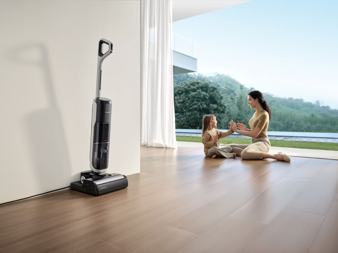 Aspirateur eau et poussière Dreame H14 Pro noir et gris dans un salon moderne, près d'une baie vitrée donnant sur un lac