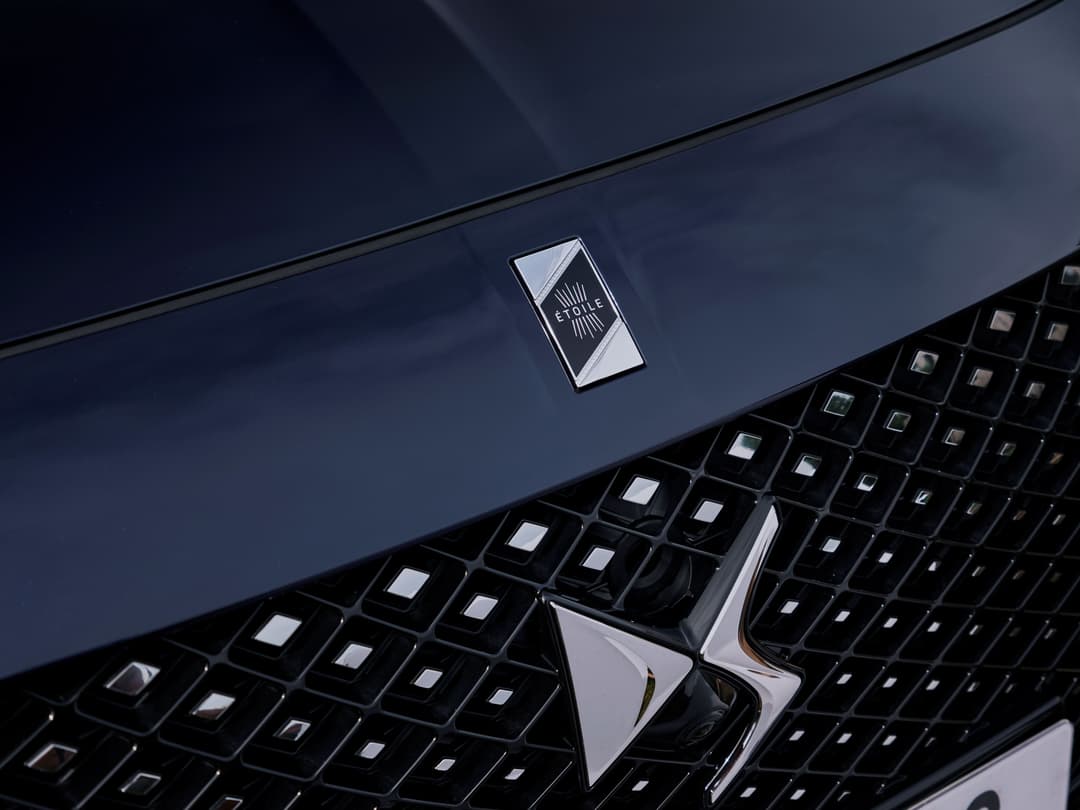 Badge Étoile sur la carrosserie bleu nuit d'une DS 3, vue de dessus de la calandre