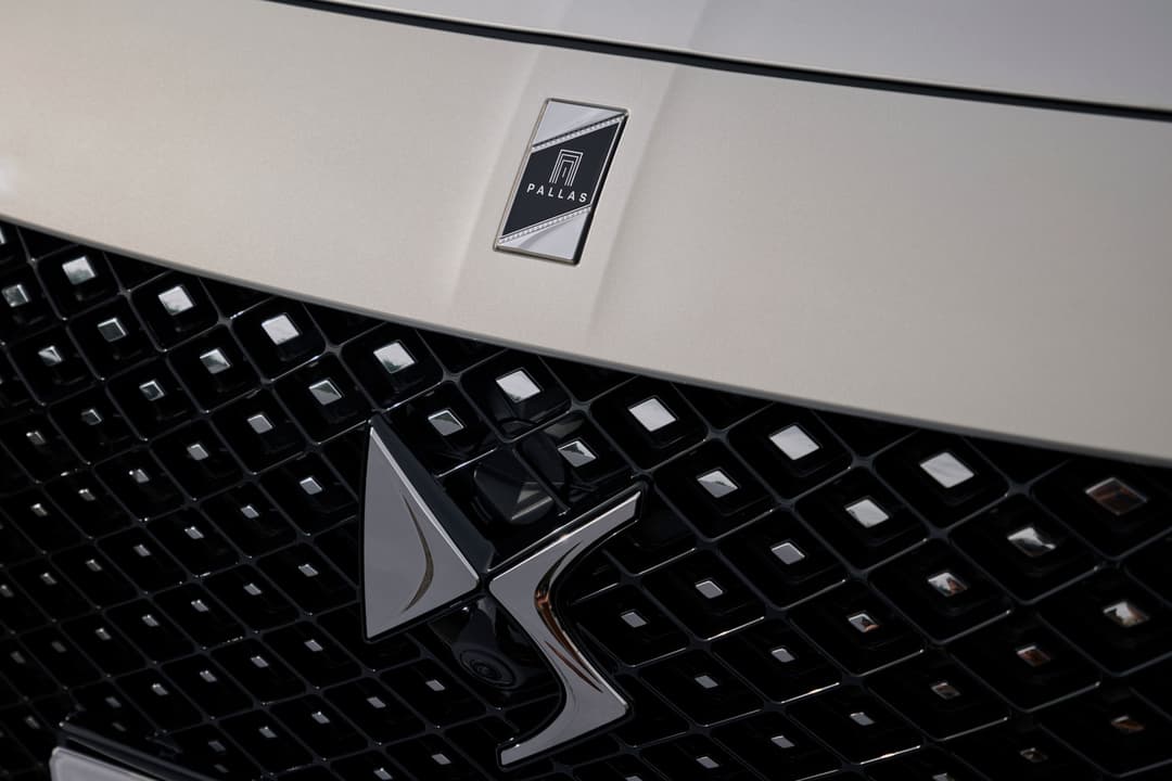 Badge Pallas en chrome et noir sur la calandre d'une DS 3, capot blanc et noir