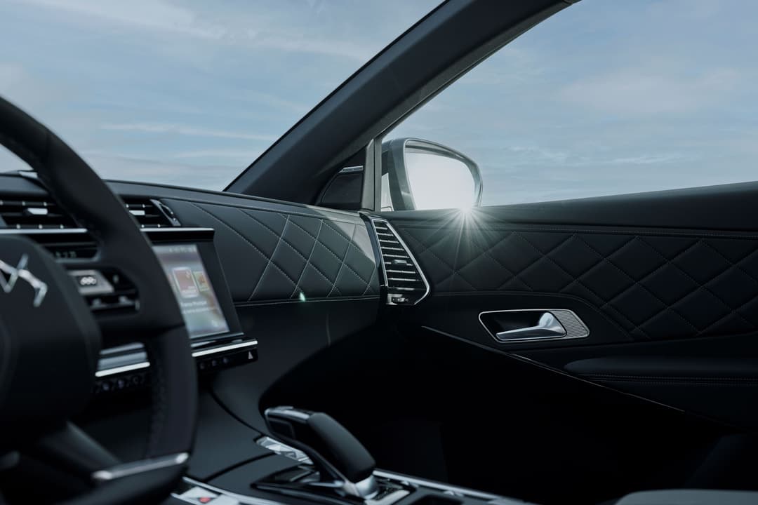Intérieur du DS 7 PALLAS avec volant et portière en Alcantara noir, garnissage matelassé et finitions aluminium