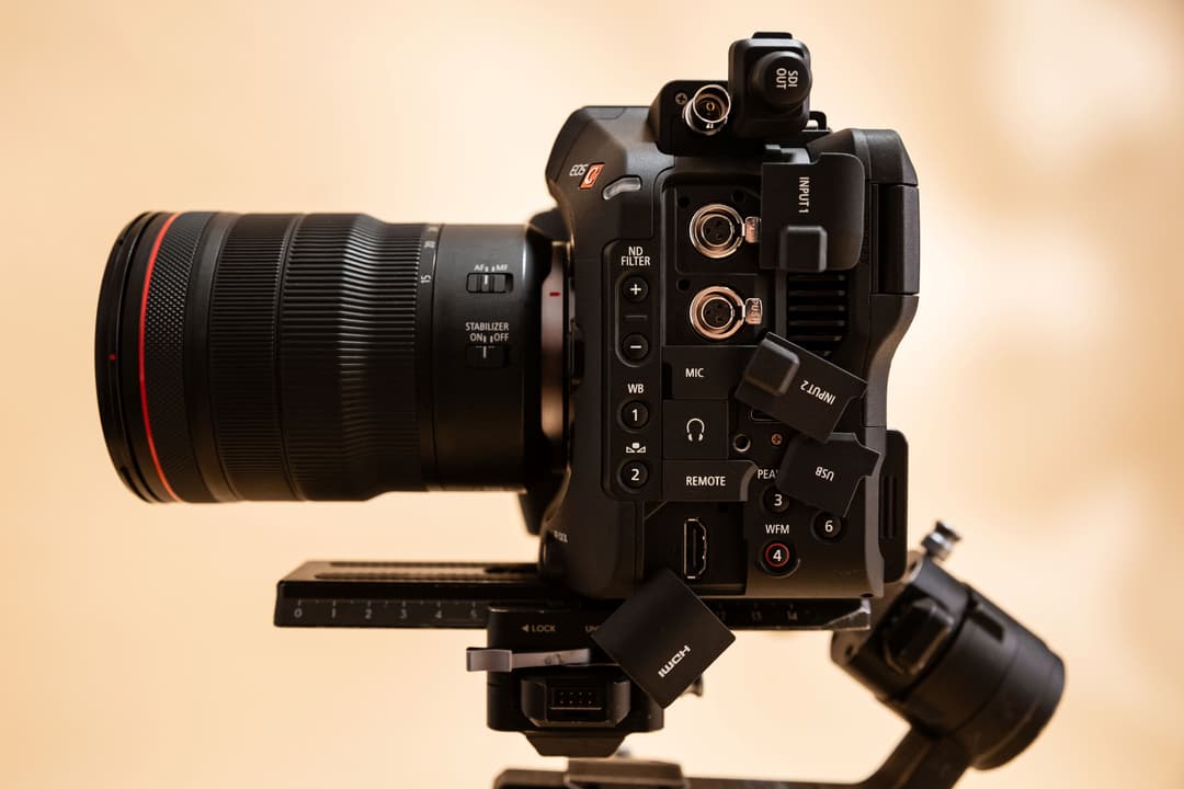 Caméra Canon EOS C80 noire avec monture RF, objectif et accessoires montés sur un pied, vue de trois quarts