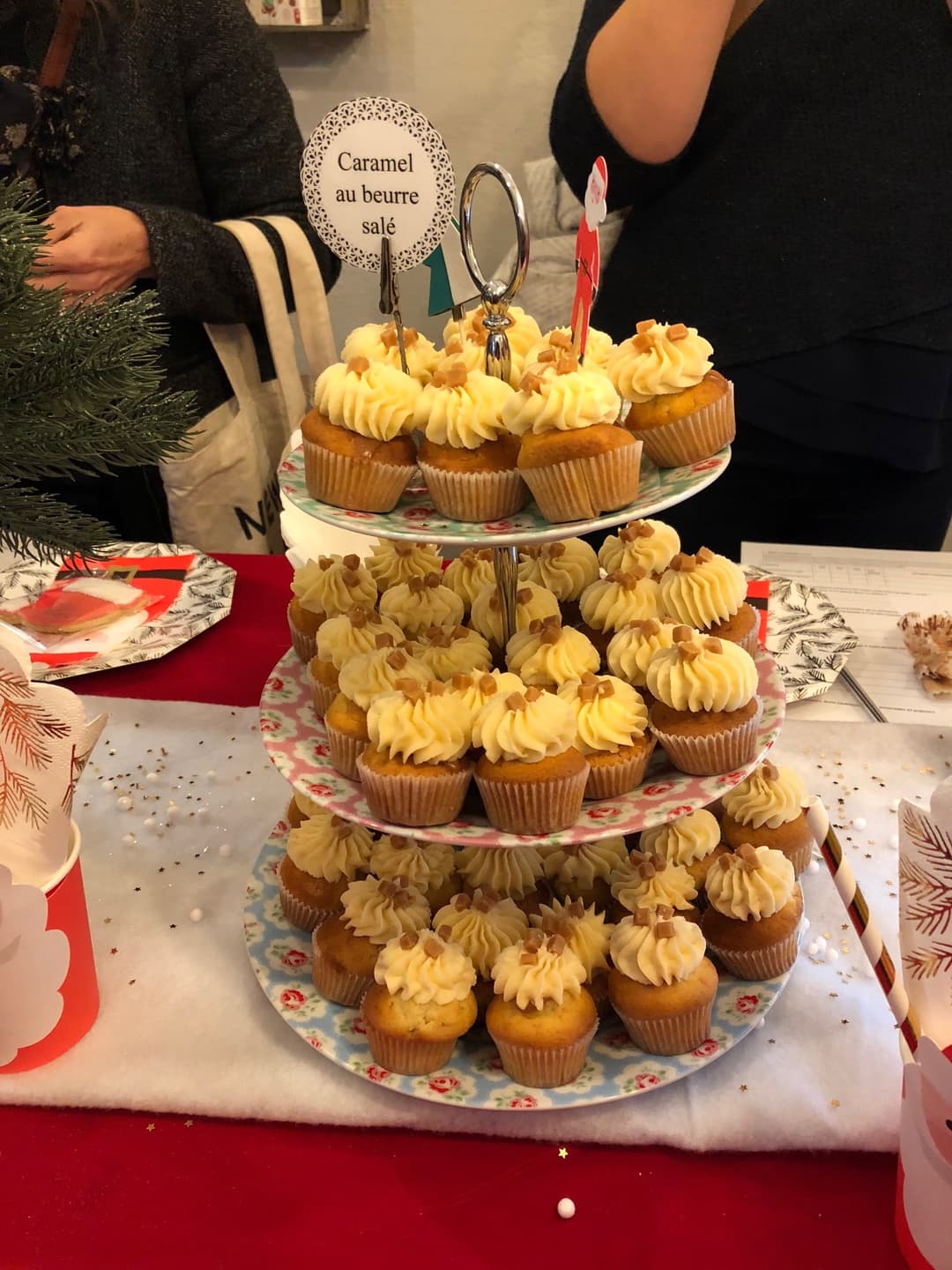 Pyramide de cupcakes au glaçage jaune citron et caramel, étiquetée « Caramel au beurre salé », présentée sur des assiettes fleuries