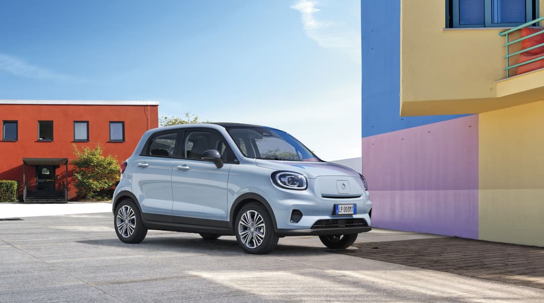 Voiture électrique Leapmotor blanche et grise garée devant des bâtiments colorés