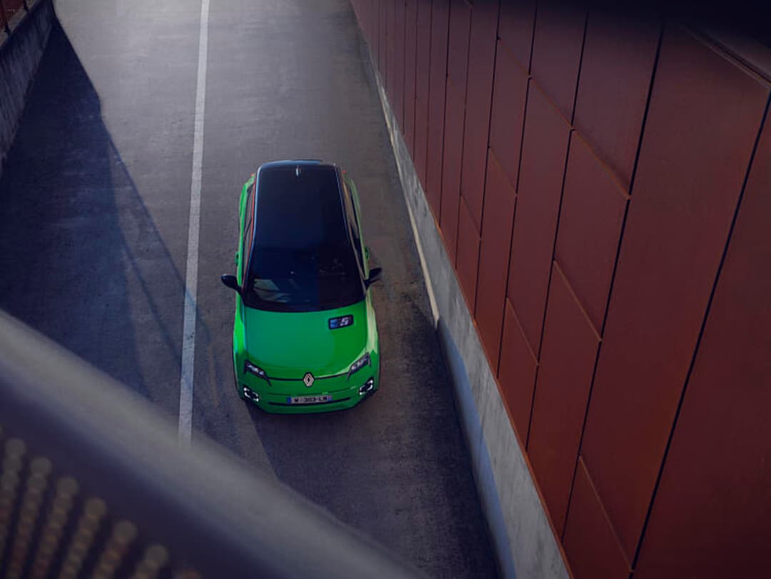 Renault 5 E-Tech 100% electric vert vif vue de dessus entre deux murs dans une usine de production