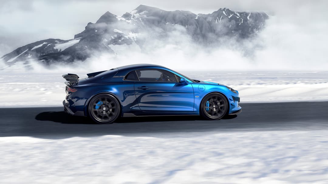 Alpine A110 R Ultime bleu dans sa configuration « La Bleue », garée sur un lac gelé avec une montagne enneigée en arrière-plan