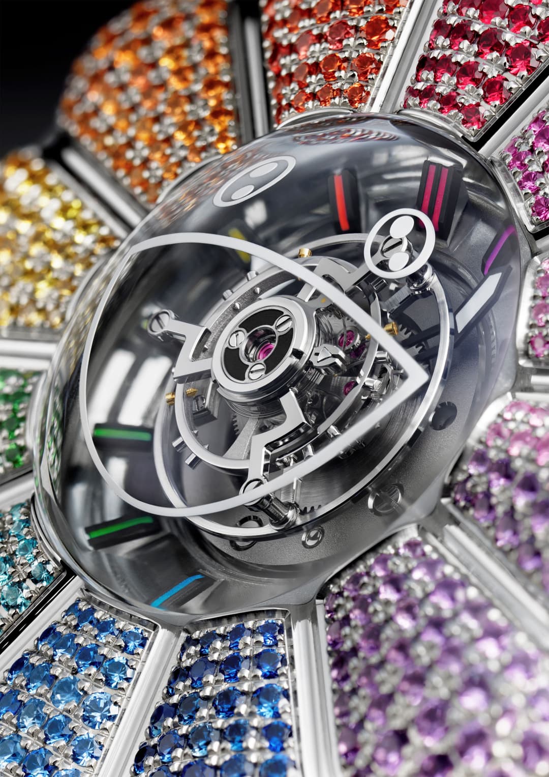 Montre MP-15 aux index colorés et mouvement squelettisé visible à travers le verre, entourée de pierres précieuses multicolores