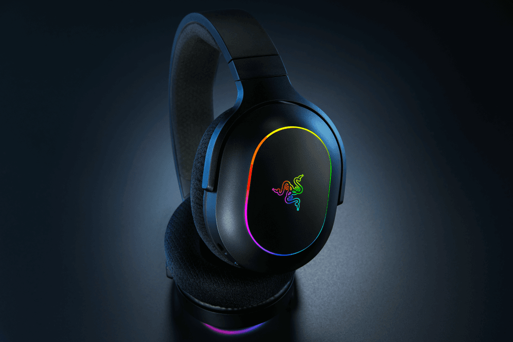 Casque gaming Razer Barracuda X Chroma noir avec arceau bleu, illuminé par des effets RGB multicolores sur les écoutilles et le tour d'oreille