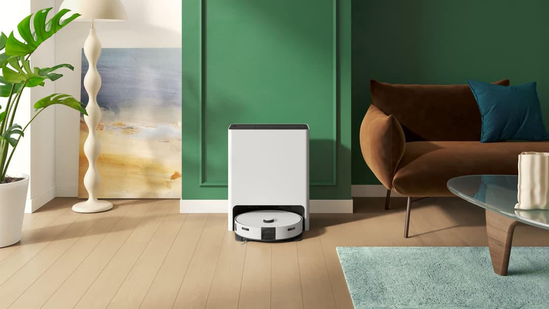 Robot aspirateur blanc et noir Samsung posé sur un parquet clair dans un intérieur moderne aux murs verts