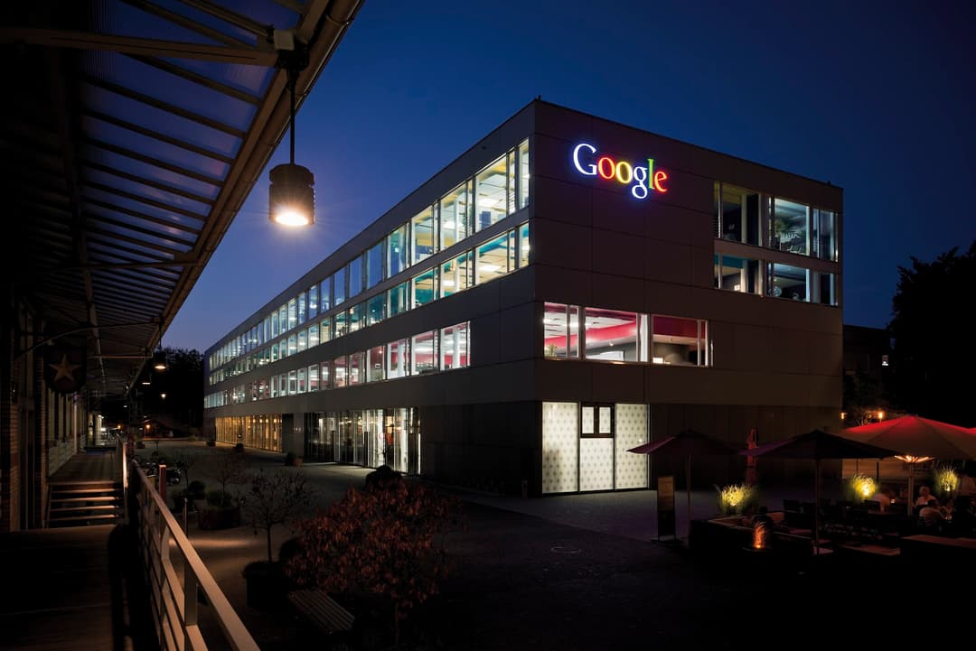 Bâtiment Google Suisse à Zurich illuminé la nuit, façade marron avec logo Google et fenêtres éclairées