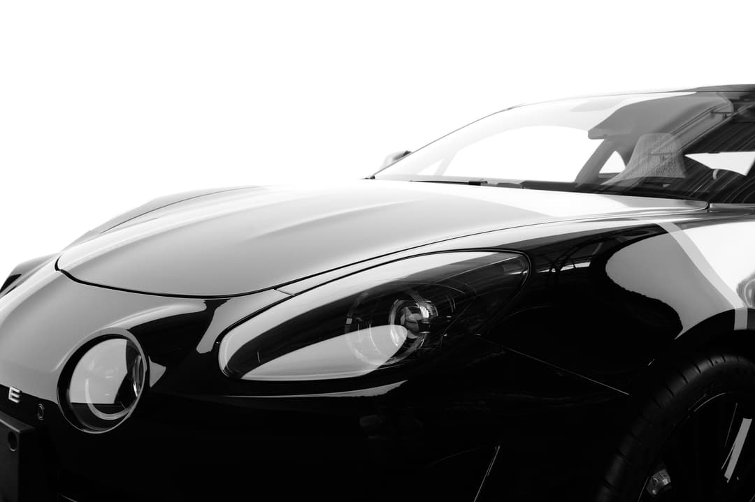 Alpine A110 S en noir et blanc, vue de profil mettant en évidence le design épuré et les contrastes de chromes