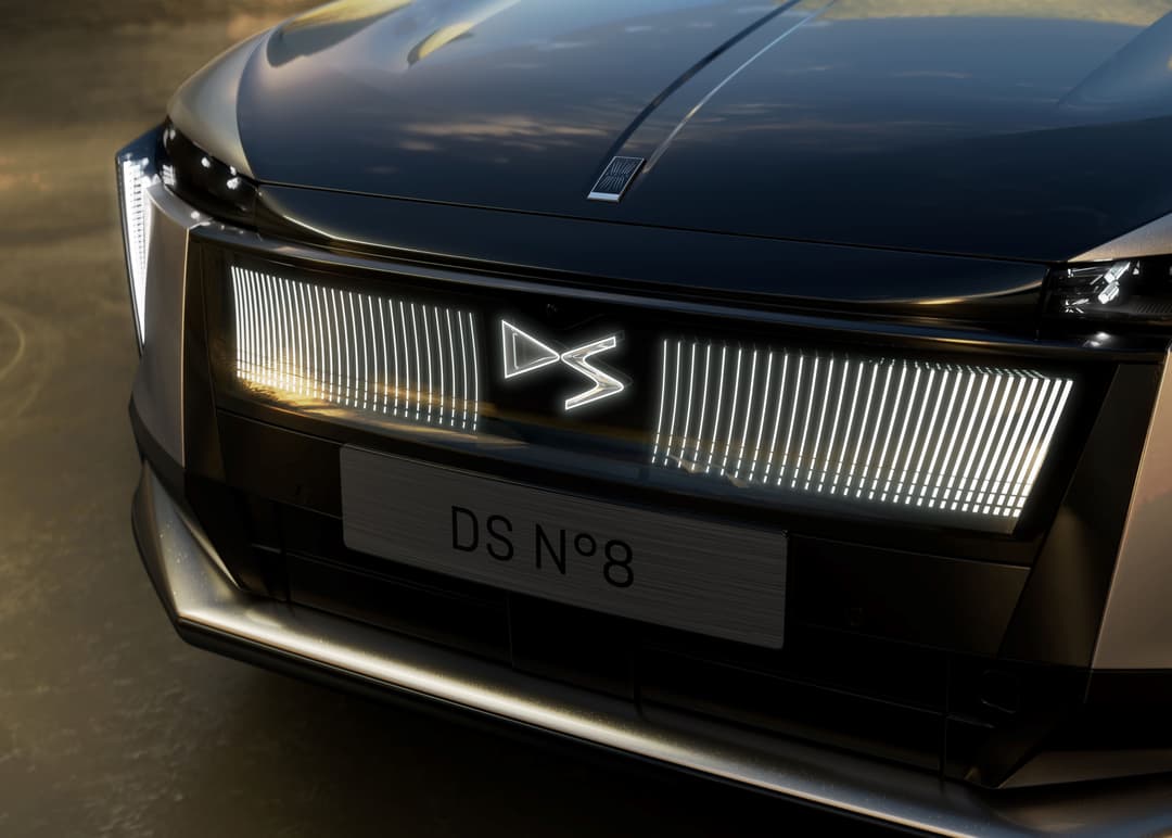 DS N°8 électrique vue de face, capot noir brillant et calandre illuminée avec motif géométrique blanc
