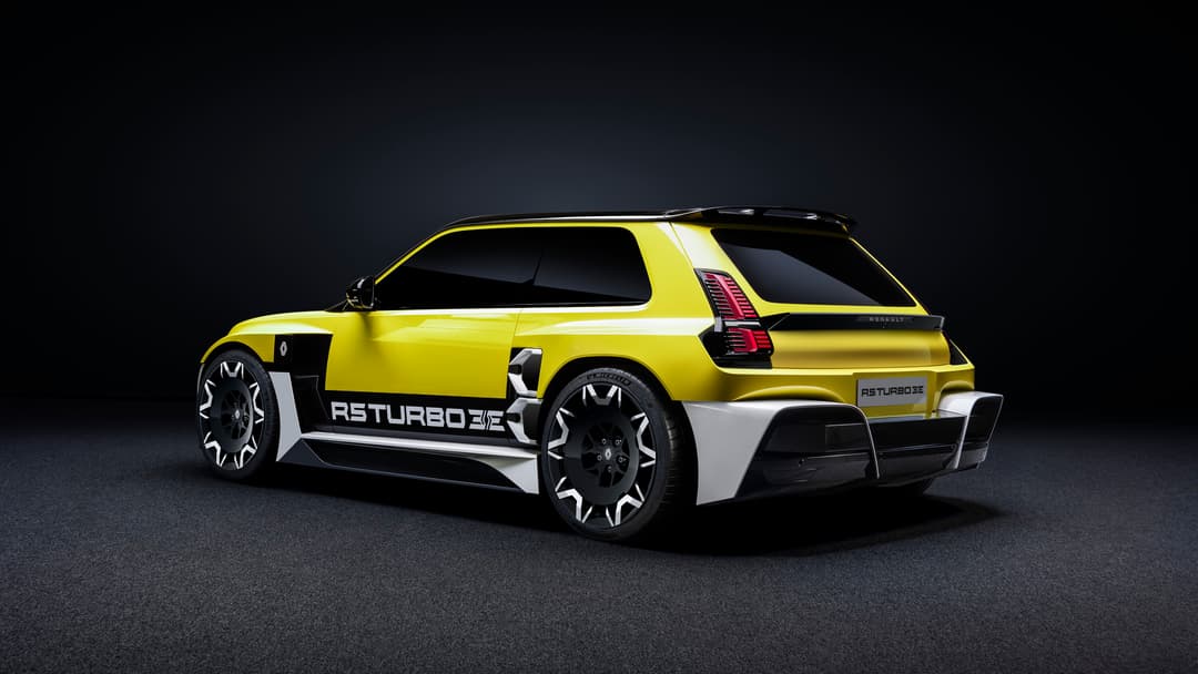 Renault 5 Turbo 3E jaune et blanche de profil sur fond noir, vue de trois-quarts arrière