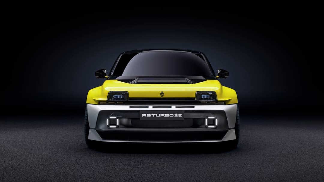 Renault 5 Turbo 3E de face, carrosserie jaune vif et noire, phares rectangulaires LED, sur fond gris foncé