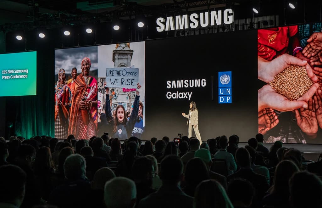 Présentatrice sur scène au CES 2025 Samsung, devant écrans géants affichant Galaxy et le logo de l'ONU