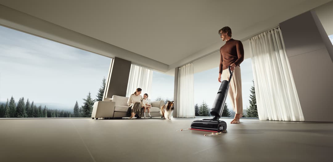 Homme utilisant l'aspirateur laveur Dreame X50 Ultra Complete dans un intérieur moderne avec baie vitrée