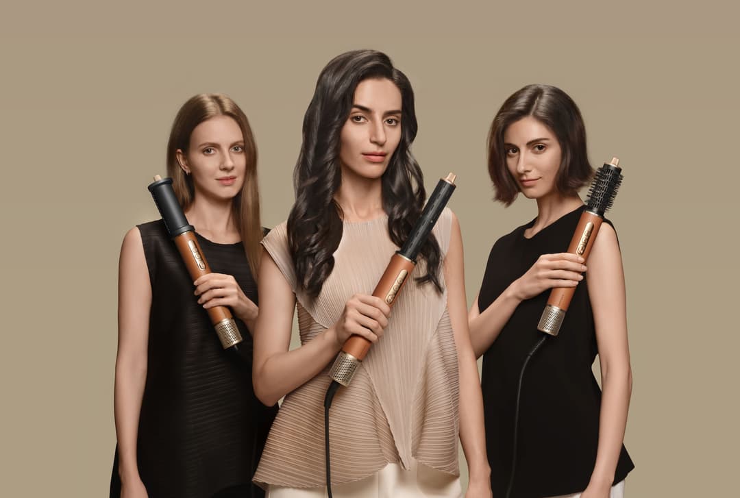 Trois femmes présentent l'outil de coiffage AirStyle Pro de Dreame aux différentes embouts de séchage et brossage
