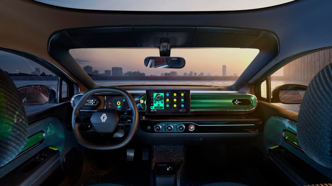 Intérieur du prototype Renault Twingo E-Tech electric avec tableau de bord futuriste, écran tactile et volant signature, accents verts fluo sur panneaux latéraux