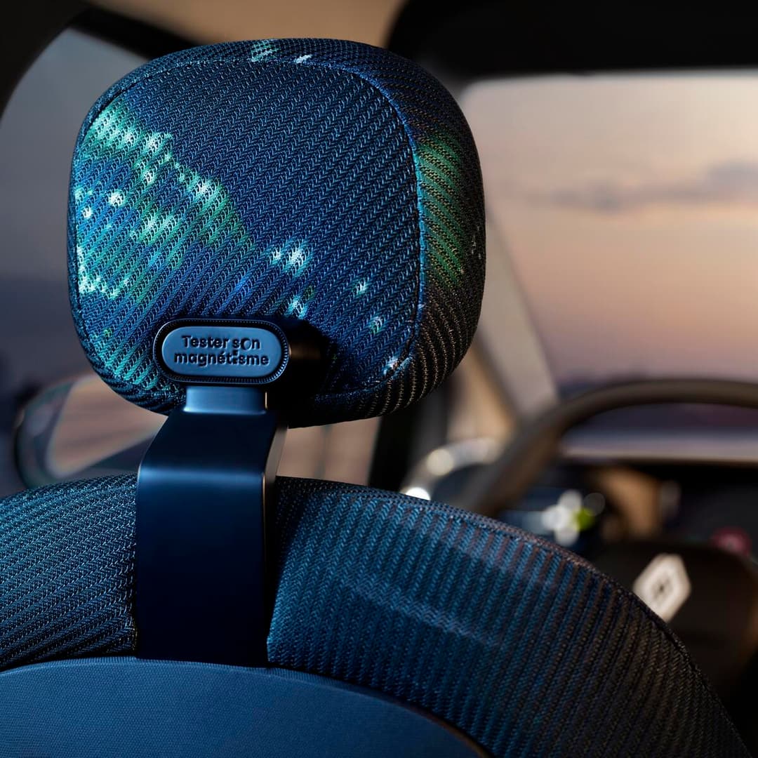 Appui-tête bleu turquoise irisé de la Renault Twingo E-Tech electric prototype, avec bouton magnétique et texture tissée