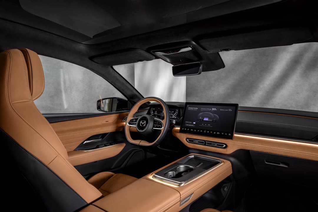 Habitacle de la Mazda6e avec sièges en cuir Tan, volant et tableau de bord en coloris caramel, écran tactile et pare-soleil électrique