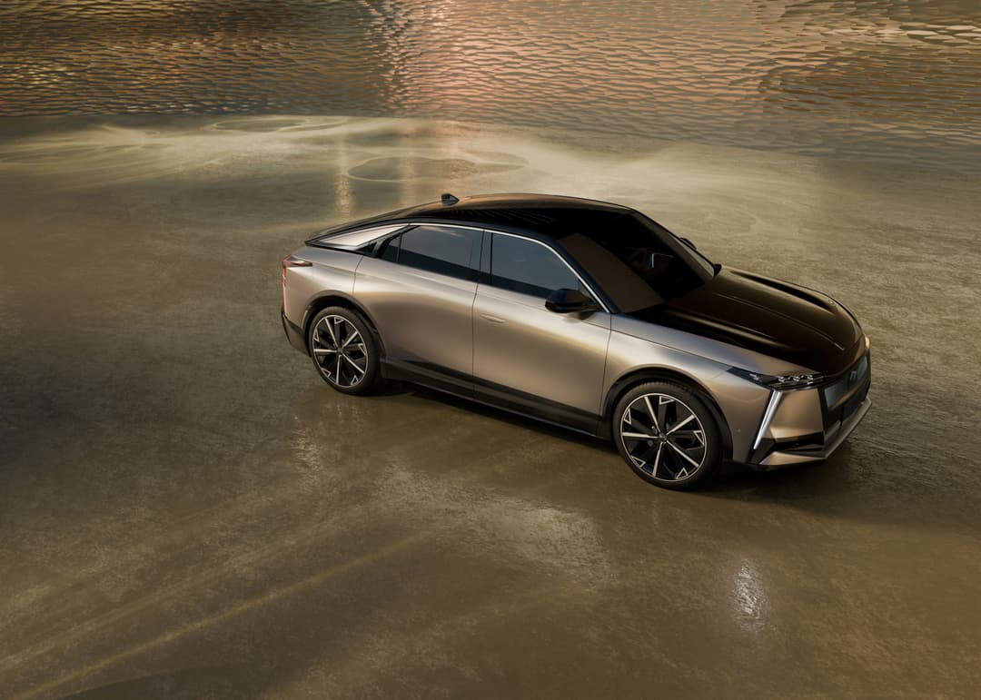 DS N°8, SUV électrique aux lignes épurées, en finition beige métallisé sur sol mouillé gris