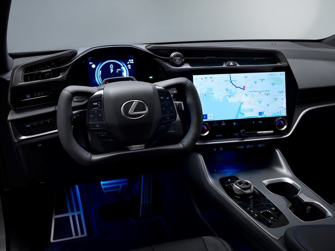 Intérieur du Lexus RZ 2025 avec volant et écran tactile affichant une carte de navigation, accents bleus luminescents