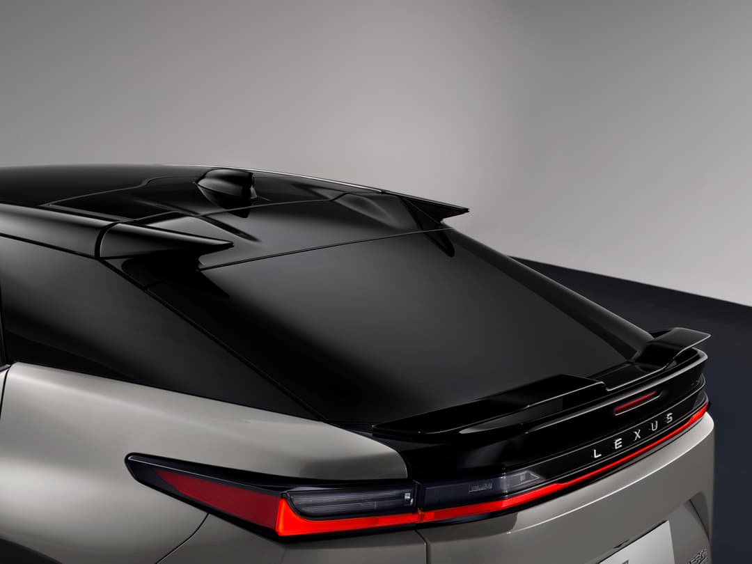 Lexus RZ 2025 vue de trois quarts arrière, carrosserie bicolore noir et blanc, toit et aileron noirs, feux arrière rouges