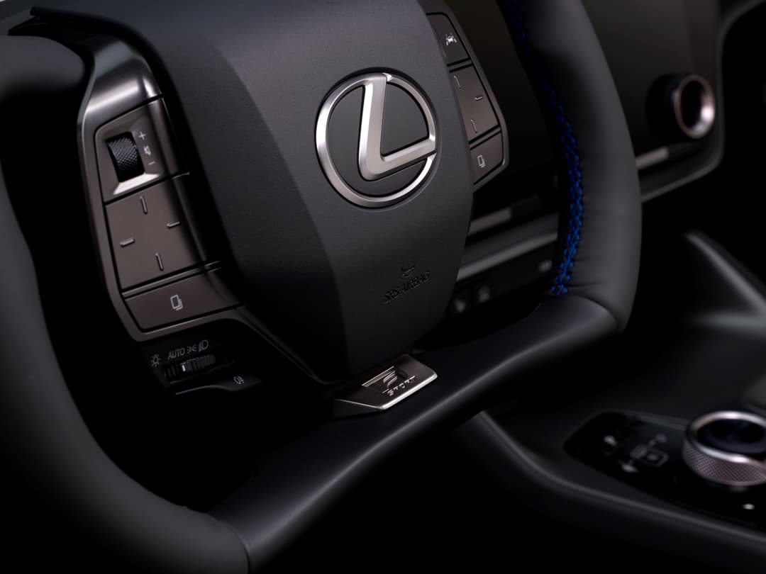 Volant du Lexus RZ 2025 avec logo de la marque, boutons de commande et détails d'insonorisation visible dans l'habitacle