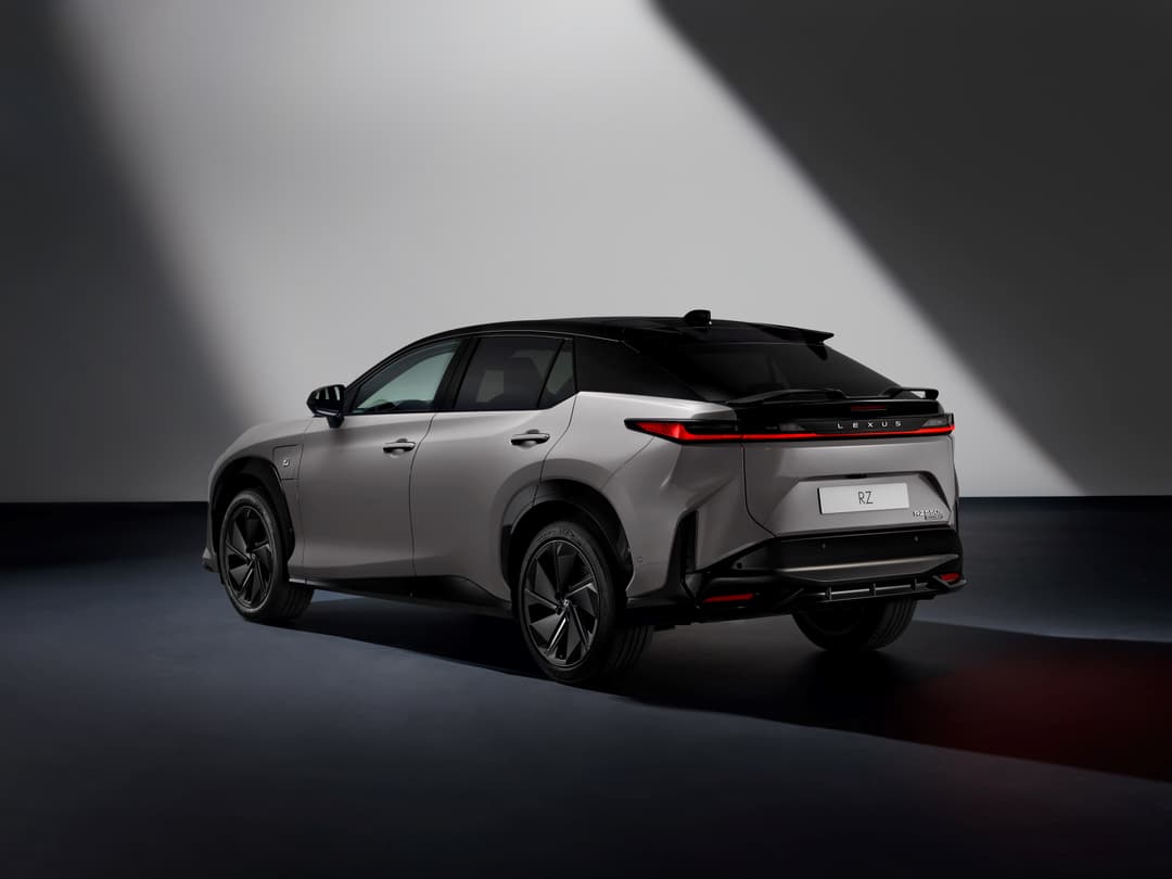 Lexus RZ 2025 gris clair vue de trois-quarts, SUV électrique aux formes épurées sur fond gris