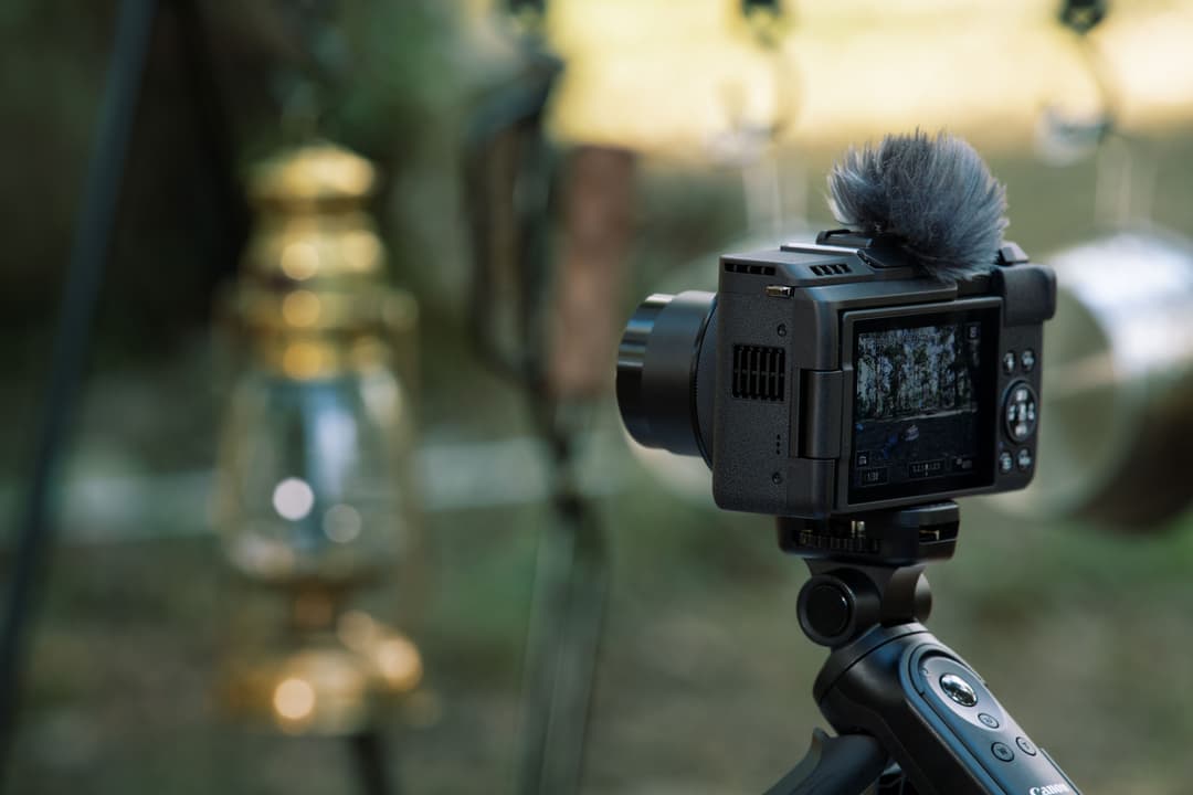 Canon PowerShot V1, caméra compacte noire avec microphone, montée sur stabilisateur avec poignée de contrôle