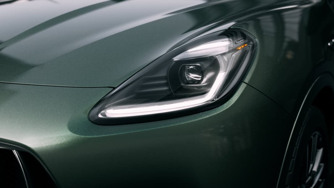 Détail du phare avant du Maserati Grecale vert foncé, avec signature lumineuse LED en forme de trait