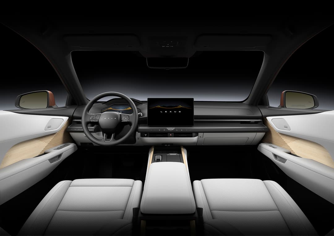 Habitacle de la nouvelle Lexus ES avec volant noir, écran central, sièges blancs et panneaux latéraux en cuir gaufré beige sous éclairage d'ambiance
