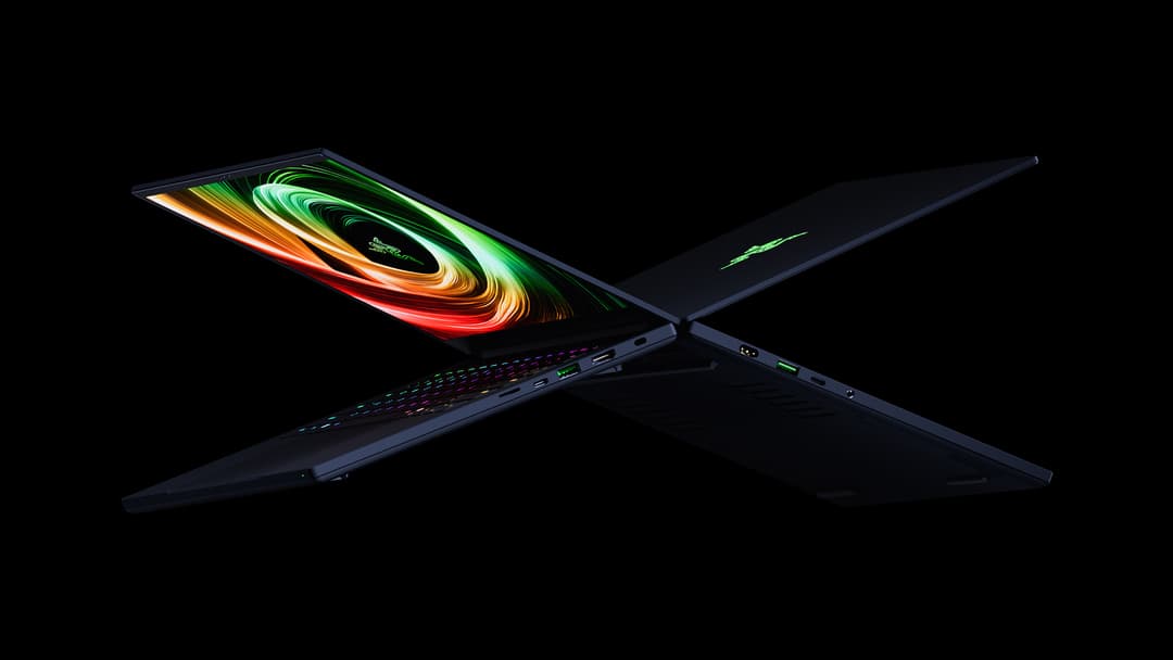 Razer Blade 14 noir ouvert, écran affichant des vagues colorées rouge et vert sur fond noir