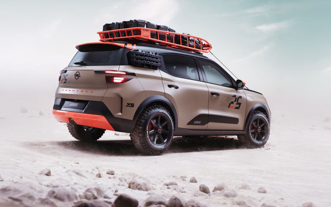 Opel Frontera GRAVEL de profil sur une plage, rouge et beige, avec galerie de toit et pneus tout-terrain