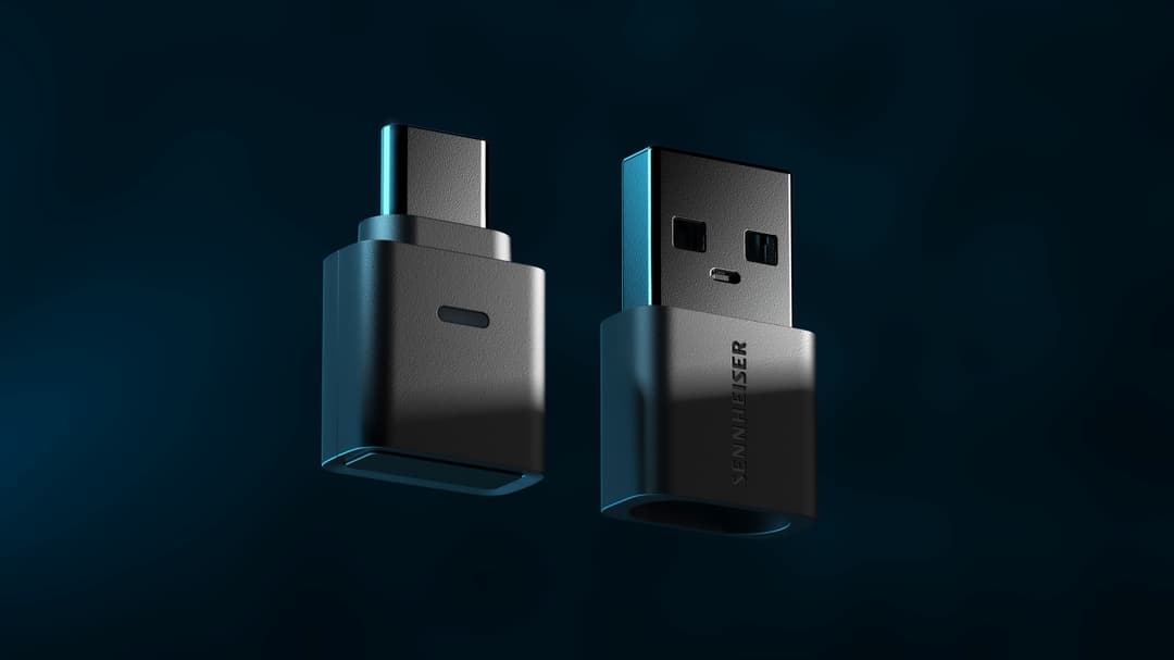 Dongle Bluetooth Sennheiser BTD 700 sous deux angles, boîtier noir et gris avec détails bleu turquoise
