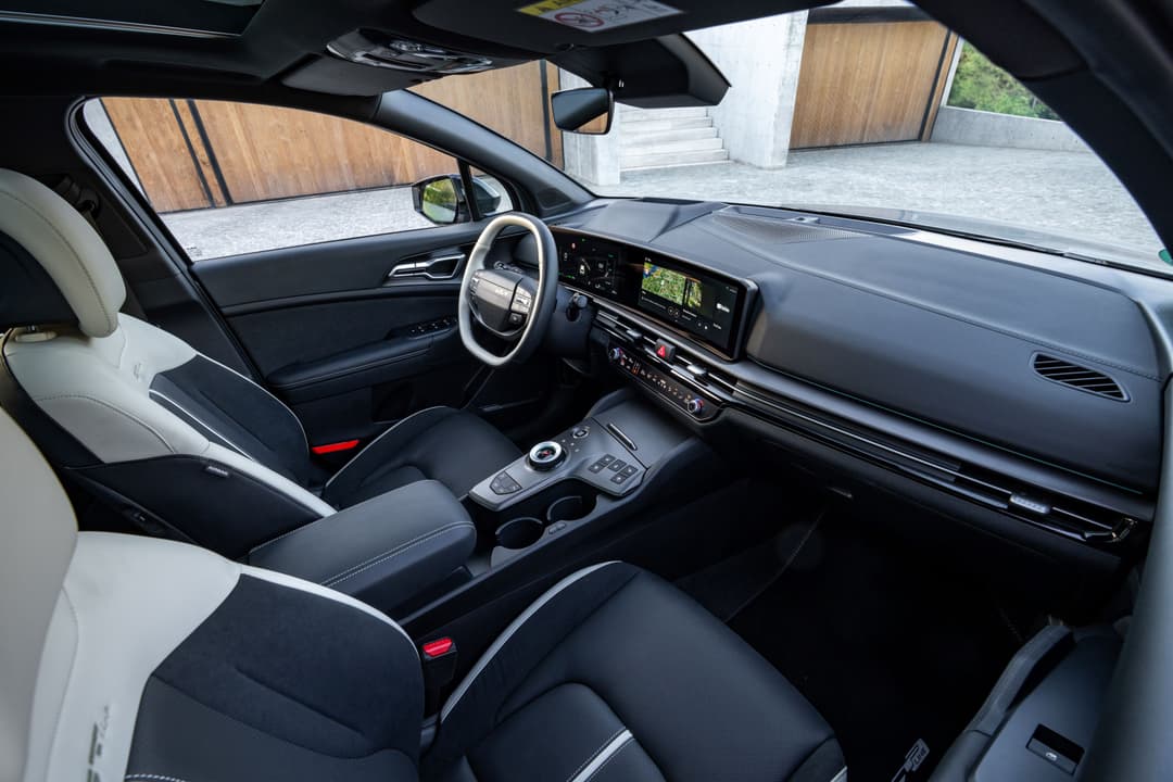 Intérieur du nouveau Kia Sportage avec sièges bicolores noir et blanc, volant moderno, tableau de bord avec écran tactile et rangements centraux