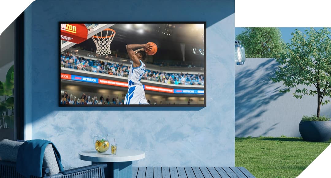 The Terrace, téléviseur d'extérieur Samsung fixé au mur bleu d'une terrasse, affichant un match de basket avec netteté en plein jour