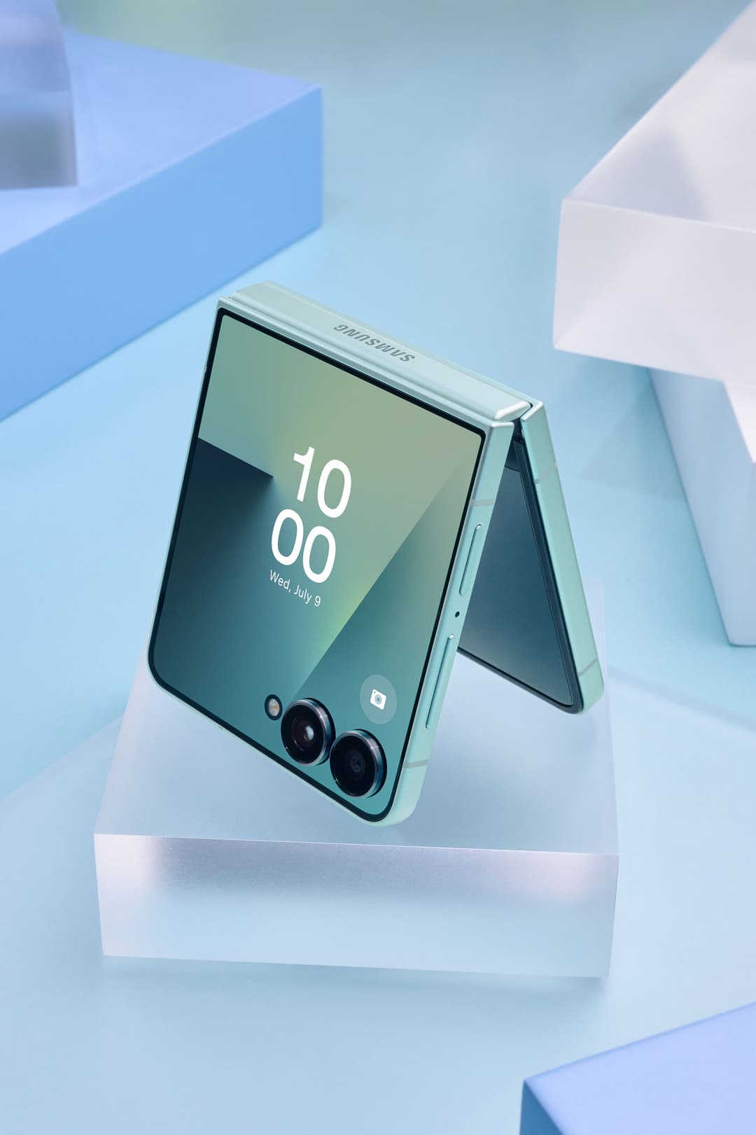 Samsung Galaxy Z Flip7 vert menthe, ouvert en mode tente, affichant l'heure 10:00 et la date du mercredi 9 juillet, avec double capteur photo à l'arrière